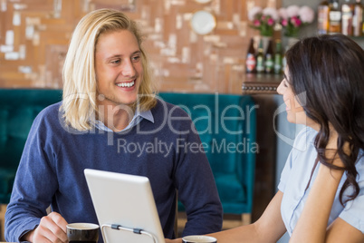 Business colleagues interacting with each other while having tea