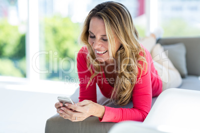 Full length of woman using cellphone on sofa