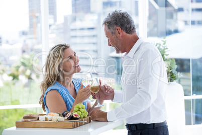 Smiling mature couple toasting white wine