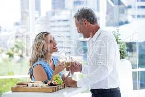Smiling mature couple toasting white wine