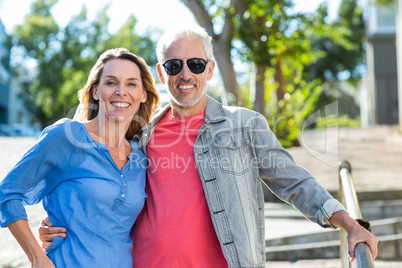 Happy mature couple standing on footpath