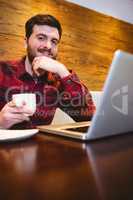 Man with laptop and coffee in restaurant