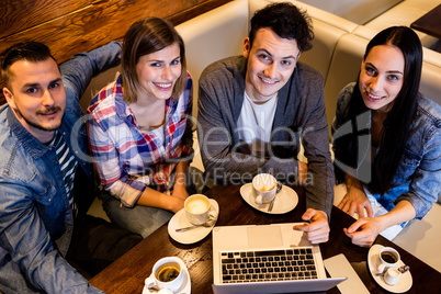 High angle view friends using laptop at restaurant