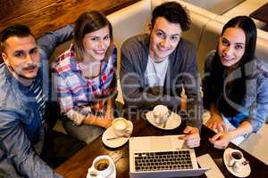 High angle view friends using laptop at restaurant