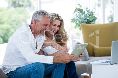 Smart mature couple using digital tablet