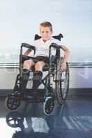 Portrait of schoolkid sitting on wheelchair