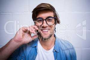 Portrait of man talking on phone against wall