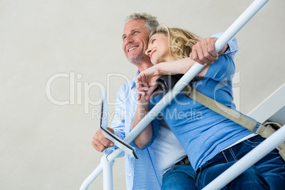 Thoughtful couple by railing at home