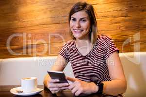 Young woman using cellphone in restaurant