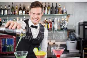 Waiter pouring cocktail into glasses