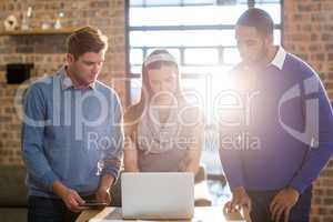 Colleagues using laptop in office