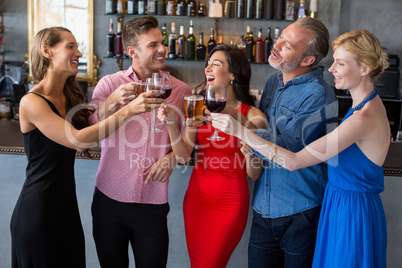 Group of friends toasting glasses of beer and wine