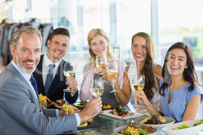 Portrait of happy business colleagues toasting beer glasses whil