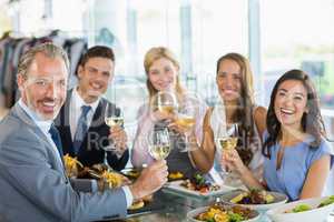 Portrait of happy business colleagues toasting beer glasses whil