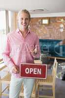 Restaurant manager holding open signboard