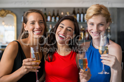 Happy female friends holding glass of champagne flute