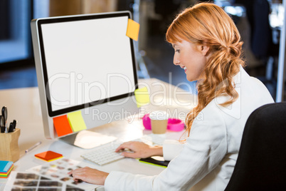 Female photo editor working at computer desk