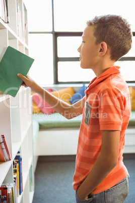 Boy taking a book from bookshelf in library