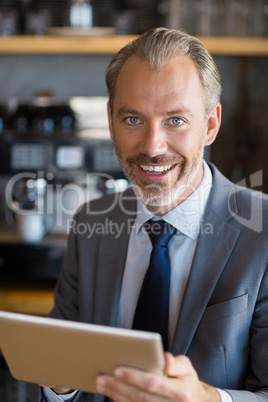 Businessman using digital tablet in cafÃ©