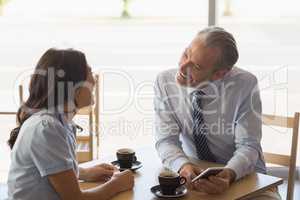 Business colleagues interacting with each other while having tea