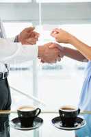 Businessman shaking hands and giving business card to colleague
