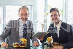 Portrait of businessmen using digital tablet in restaurant