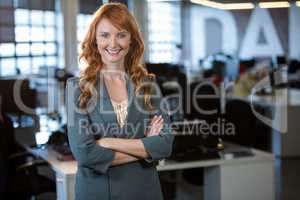 Confident businesswoman standing by desk