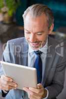 Businessman using digital tablet in cafÃ©