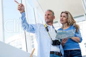 Front view of mature couple holding map