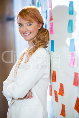 Pretty businesswoman leaning on whiteboard
