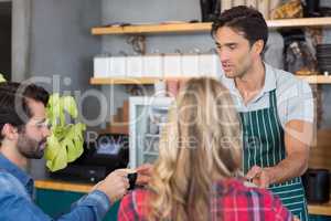 Waiter offering coffee to a couple