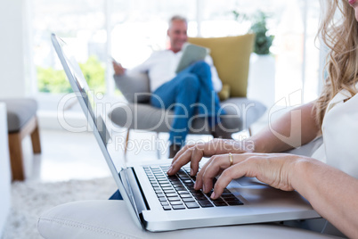 MIdsection of woman with laptop by man using technology