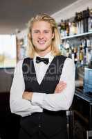 Waiter with arms crossed standing in restaurant
