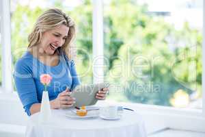 Happy mature woman holding digital tablet