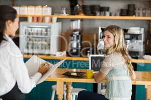 Woman ordering coffee from waitress
