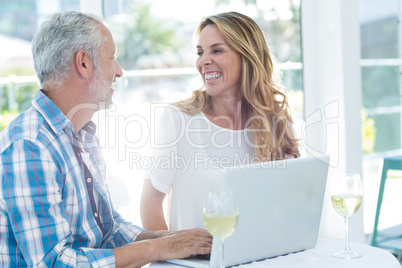 Mature couple by table in restaurant