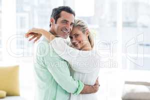 Portrait of mid adult couple hugging at home