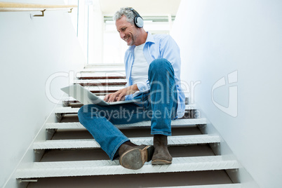 Full length of mature man using laptop