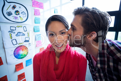 Young man kissing female colleague Young man kissing female colleague