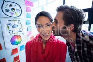 Young man kissing female colleague