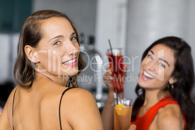Two beautiful women holding cocktail glass