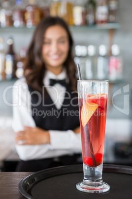 Close-up of cocktail glass in tray with waitress in background