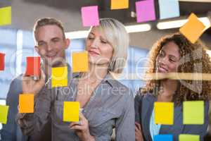 Businesswoman explaining to colleagues over sticky notes
