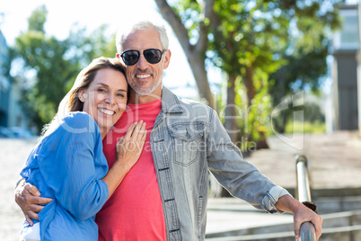 Smiling mature couple standing on footpath