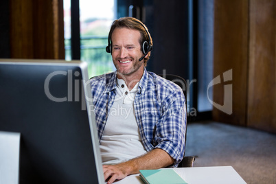 Creative businessman smiling while working on computer