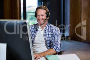 Creative businessman smiling while working on computer