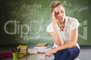 Tensed school teacher sitting in classroom