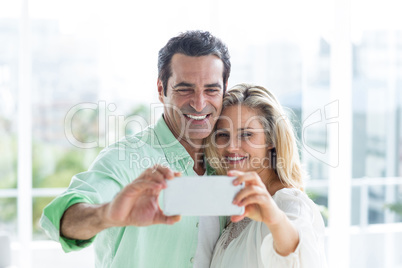 Mid adult couple taking selfie at home