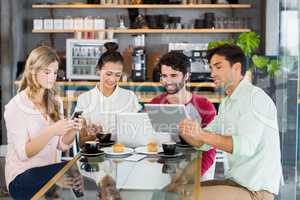 Group of friends using mobile phone, digital tablet and laptop