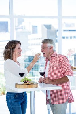 Smiling woman feeding food to man